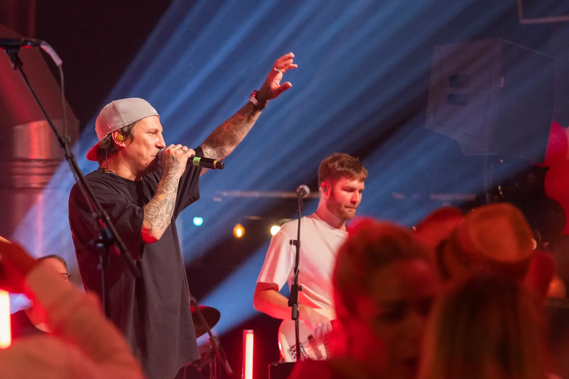 Vokalist på scenen i blått og rødt scenelys