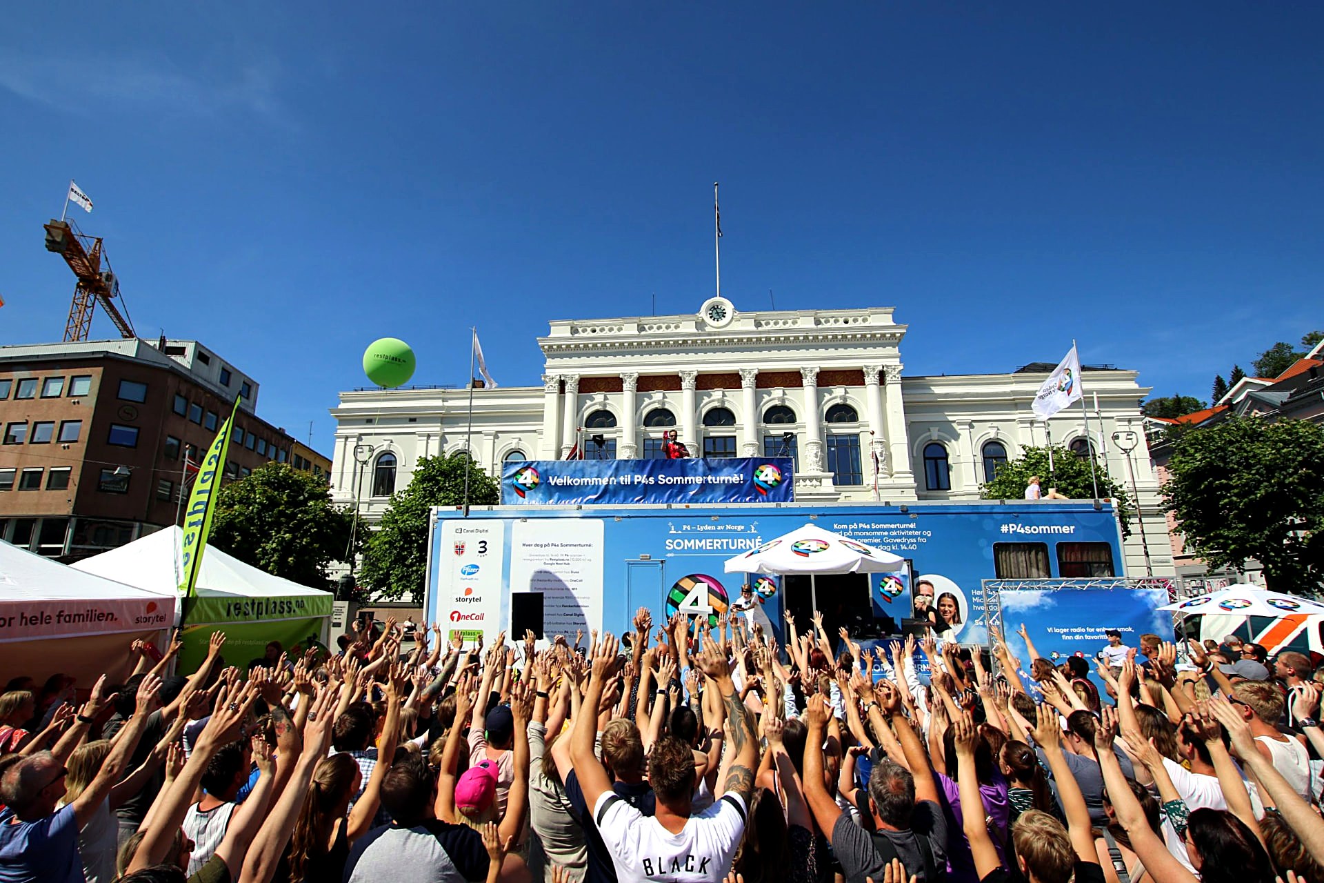 Publikum foran P4-turnébussen og scenen med påskriften «Velkommen til P4s Sommerturné»