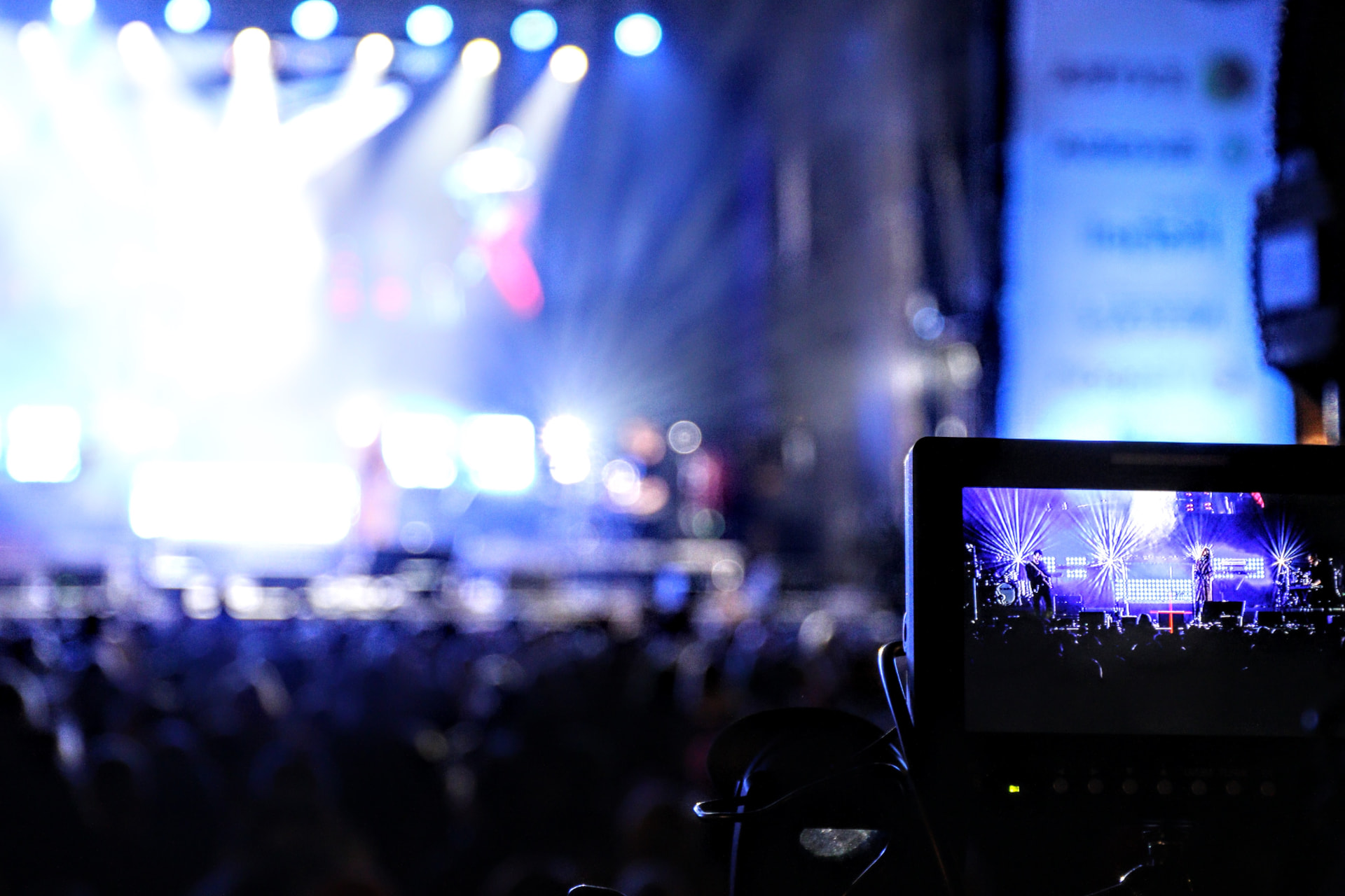 TV-monitor viser konserten mens scenen lyser i bakgrunnen