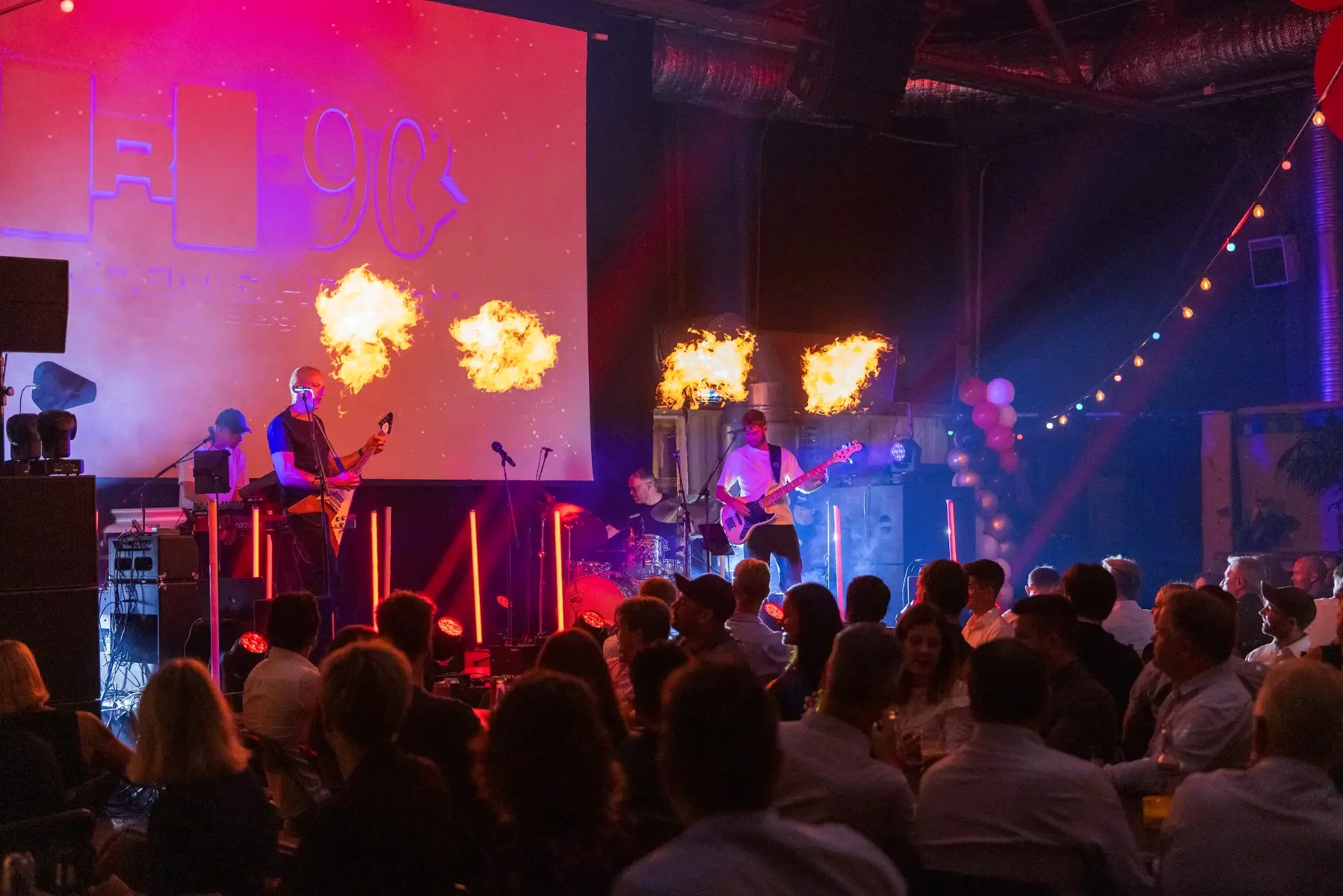 Band på scenen med flammeeffekter foran gjestene