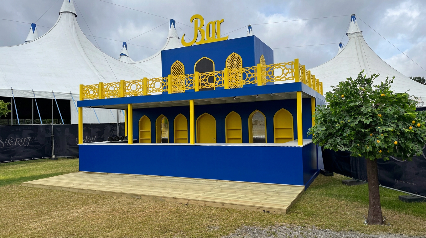 Det blå og gule huset med buede åpninger, gule ornamenterte rekkverk og tredekk foran